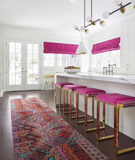 FLOR Over The Moon runner rug in Persimmon in a white, pink, and gold kitchen.